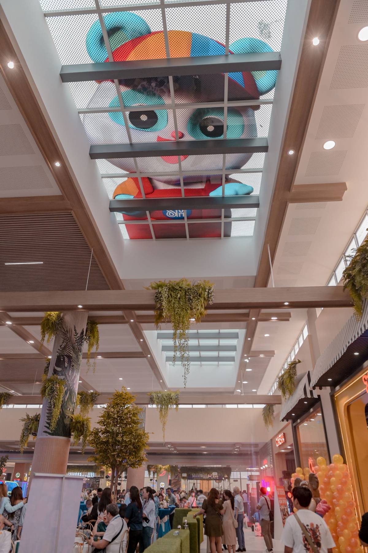 Cali, the mall's huggable 25-foot inflatable panda, peeks through the 3rd-level ceiling to welcome everyone.